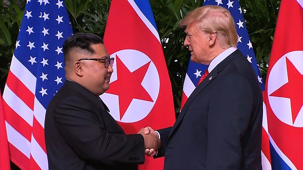 Donald Trump and Kim Jong Un shake hands