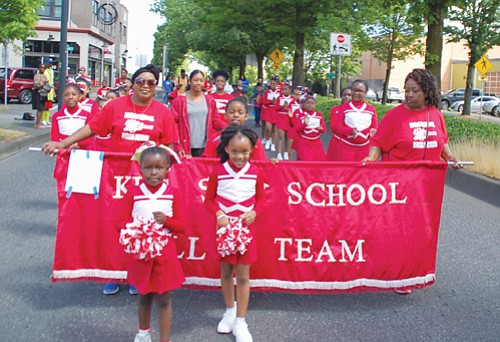 The younger King Sun School Drill team marches with a banner of school pride.