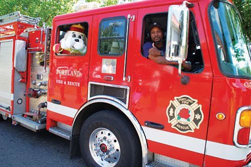 A Portland Fire and Rescue firefighter and his fluffy friend are thumbs up for Portland’s freedom parade.