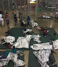 Immigrants are seen here inside a detention center with mattresses and thermal blankets on the floor.