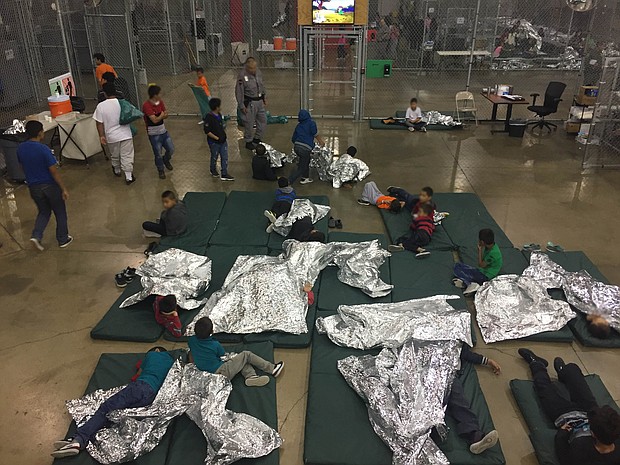 Immigrants are seen here inside a detention center with mattresses and thermal blankets on the floor.