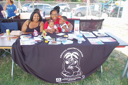 Malik Mathis (left) and Destiny Redmond of Multnomah County’s Healthy Birth Initiatives bring health information to the public at Good in the Hood.