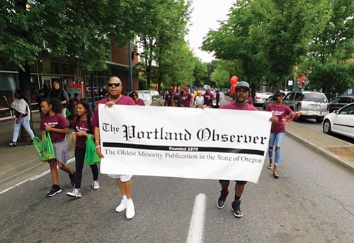 Representatives of the Portland Observer, Oregon’s longest continuous minority-owned newspaper, march down Martin Luther King Jr. Blvd.