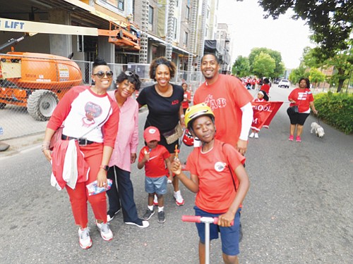 Parade-goers young and old enjoy the sunny day as the parade route stretches along Martin Luther King Boulevard.