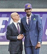 Deandre Ayton poses for photos in a Phoenix Suns cap after being selected by the team as the first pick of the NBA draft last Thursday at the Barclays Center in New York. The 7-foot Ayton is congratulated by NBA Commissioner Adam Silver. 