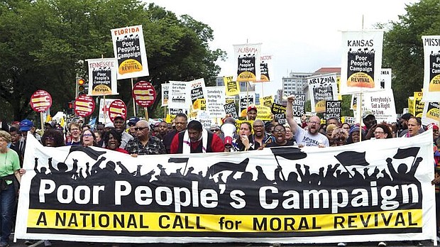 Demonstrators led by the Rev. William J. Barber II, center wearing red shirt, march outside the Capitol in Washington during last Saturday’s Poor People’s Campaign rally on the National Mall.