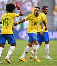 Neymar celebrates with teammate Willian after scoring his team's first goal against Mexico July 2, 2018.  Full credit: Dan Mullan/Getty Images Europe/Getty Images