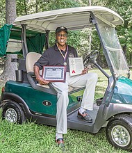 John Houze Jr. holds in his right hand the patent for his retractable golf canopy that is attached to the roof of his golf cart. Mr. Houze also holds the application for the patent, which was filed two years ago and granted in May 2018.