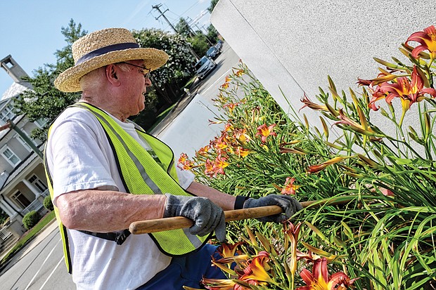 CITYSCAPE-Slices of life and scenes in Richmond-
Volunteers from the Richmond Tennis Association add touches of color, including their own green thumbs, to the Arthur Ashe Monument at Monument and Roseneath avenues in Richmond’s West End. Joe Grover cleans a bed of bright lilies. This is the fourth year that the association has conducted the beautification project.