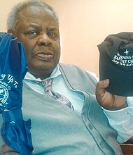 The Rev. Ernest Blue Jr. shows the umbrella and baseball cap he received from Morning Star Baptist Church’s pastor after preaching a guest sermon on July 1. 