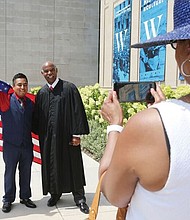 New citizens-
 Judge Roger L. Gregory, chief judge of the 4th U.S. Circuit Court of Appeals in Richmond, talks to 96 immigrants and their family members during the Fourth of July naturalization ceremony where they officially became U.S. citizens. The ceremony was held outside the Virginia Museum of History and Culture on the Boulevard. Richmond resident Beato Hernandez, 33, a native of Mexico, poses for a photo with Judge Gregory after the ceremony. 