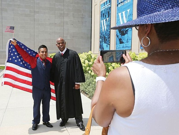 New citizens-
 Judge Roger L. Gregory, chief judge of the 4th U.S. Circuit Court of Appeals in Richmond, talks to 96 immigrants and their family members during the Fourth of July naturalization ceremony where they officially became U.S. citizens. The ceremony was held outside the Virginia Museum of History and Culture on the Boulevard. Richmond resident Beato Hernandez, 33, a native of Mexico, poses for a photo with Judge Gregory after the ceremony. 