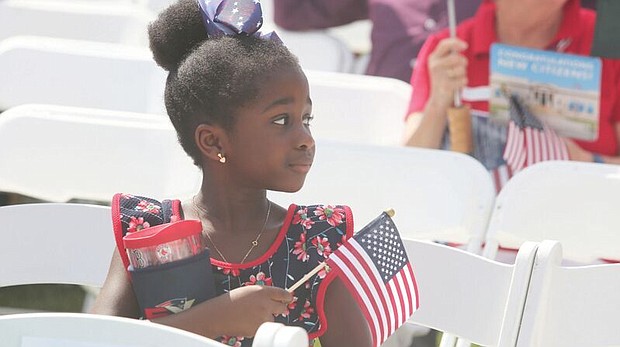 Celebrating a new American-
Arielle Lawson Drackey, 6, waits with family members for her father, Late Lawson Drackey of Fredericksburg, as he takes the oath of citizenship during a July 4 naturalization ceremony at the Virginia Museum of History and Culture. 