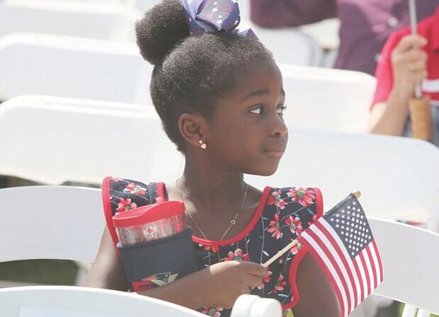 Celebrating a new American-
Arielle Lawson Drackey, 6, waits with family members for her father, Late Lawson Drackey of Fredericksburg, as he takes the oath of citizenship during a July 4 naturalization ceremony at the Virginia Museum of History and Culture. 