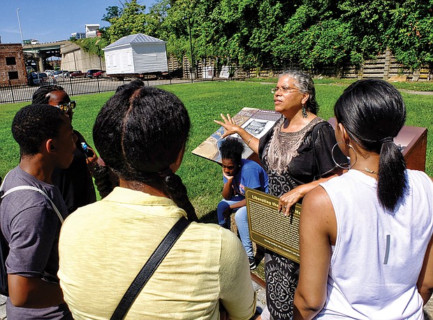 Ana Edwards, chair of the Sacred Ground Historical Reclamation Project, leads a tour in July 2016 of the African Burial Ground and Lumpkin’s Jail site in Shockoe Bottom. Her audience is composed of young people taking part in a summer leadership program sponsored by the Maggie Walker National Historic Site.    