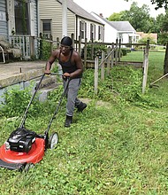 Michael Beckley, 17, mows the lawn while Xavier Edmonds, 16, whacks weeds last Saturday at a vacant home on Garber Street in Fulton before seeking customers for paying jobs through the 4-H Lawn Maintenance Program started by Wyatt Kingston.