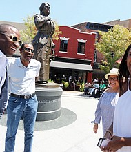 Courtyard of the Maggie L. Walker National Historic Site at 2nd and Leigh streets in Jackson Ward. Liza Mickens shares a laugh Saturday at the statue of her great-great-grandmother, Maggie L. Walker, in Downtown with, from left, Mayor Levar M. Stoney, and her parents, Dr. Johnny Mickens III and Faithe Norrell at the the 154th birthday celebration for Mrs. Walker and the ceremony recognizing graduates of the park service’s Maggie L. Walker Summer Youth Leadership Institute. 