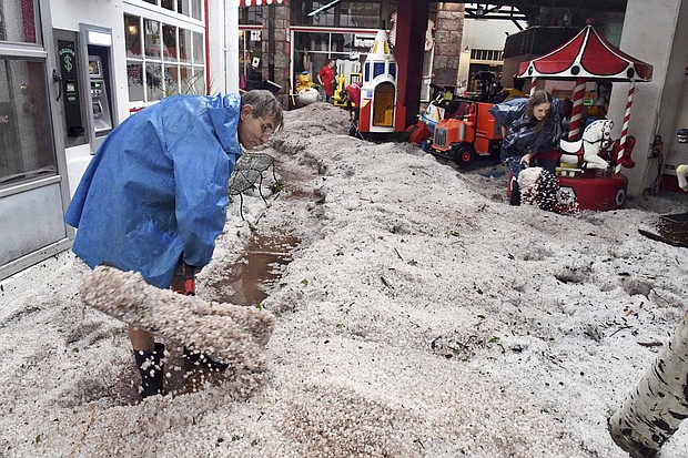 Ron Allen, an employee with the Manitou Springs Penny Arcade, and other employees dig out of hail drifts.