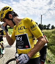 Tour de France leader Geraint Thomas cleans his eyes after tear gas was used during a farmers' protest.