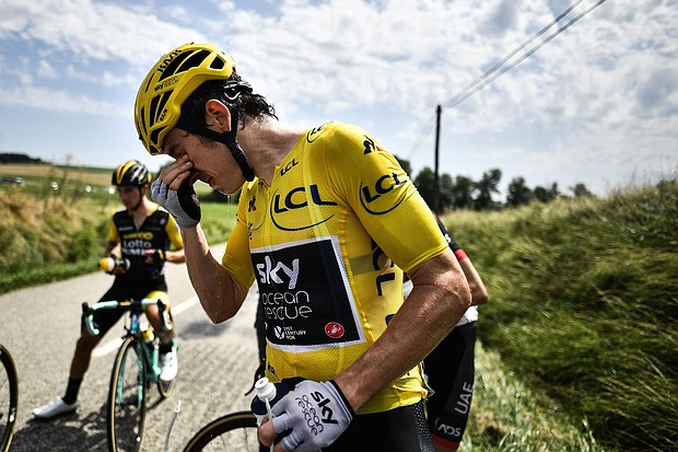 Tour de France leader Geraint Thomas cleans his eyes after tear gas was used during a farmers' protest.