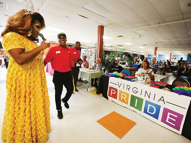 Virginia is for lovers and pride
Alvion Davenport, left, Ms. Black RVA Pride takes the microphone to highlight several of the organizations and vendors at last Saturday’s inaugural Black Pride RVA at Diversity Richmond in North Side. The two-day event, designed to educate, embrace and celebrate the unique experiences of Richmond’s black LGBTQ community, drew several hundred people despite rain that moved the event indoors. Featured were speakers and workshops on a variety of topics, entertainment and a worship service Sunday at Third Street Bethel AME Church. Intern Tariq Crumbly, a recent Virginia Commonwealth University graduate, helped with the event.
