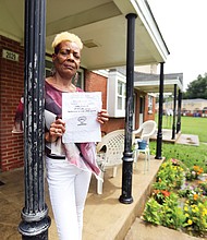 Gwendolyn Harris holds a notice from Richmond Redevelopment and Housing Authority telling her she must come to the Creighton Court management office to sign a lease amendment that embodies the new regulation banning smoking. 