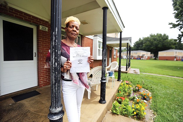 Gwendolyn Harris holds a notice from Richmond Redevelopment and Housing Authority telling her she must come to the Creighton Court management office to sign a lease amendment that embodies the new regulation banning smoking. 