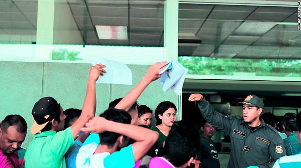 A Costa Rican immigration officer requests documents from Nicaraguans at the border on July 24.