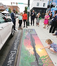 Mayor Levar M. Stoney takes part in a tour of the new artwork decorating four storm drains in Carytown. Here, the group is viewing Elise Neuschler’s “Deep Texas Beach” mural at Cary and Sheppard streets.
The goal: To encourage the public to help end pollution of city streams and the James River by not using storm drains as trash bins. 