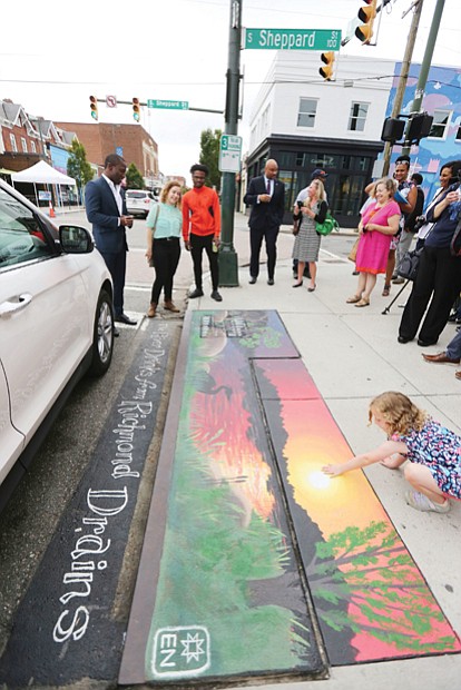Mayor Levar M. Stoney takes part in a tour of the new artwork decorating four storm drains in Carytown. Here, the group is viewing Elise Neuschler’s “Deep Texas Beach” mural at Cary and Sheppard streets.
The goal: To encourage the public to help end pollution of city streams and the James River by not using storm drains as trash bins. 