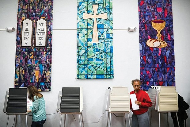 In this November 2016 photo, voters fill our their ballots at a polling place inside Pleasant Ridge Presbyterian Church in Cincinnati.