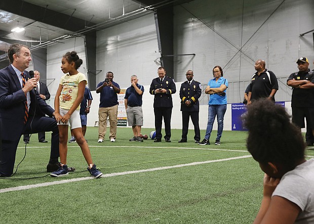 Gov. Ralph S. Northam takes a knee to hear the question posed by 9-year-old Kimoni Jenkins, 9, Wednesday morning during his visit to the Richmond Police Athletic League Summer Camp in North Side. The governor spent an hour fielding questions from the 130 youngsters at the camp.