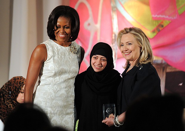 Former First Lady Michelle Obama (left) and then-Secretary of State Hillary Clinton pose with Samar Badawi of Saudi Arabia as she receives the International Women of Courage Award in 2012.