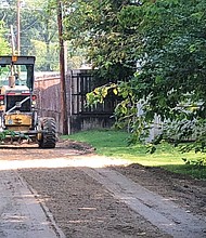 William Smyre, a member of a DPW crew, grades an alley Monday in the 2900 block of Barton Avenue in North Side. He was part of a city Department of Public Works crew operating in the East End on Monday. 