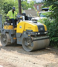 Jesse Hendren, above, uses a roller to pack down the dirt to improve an alley off Pink Street in Church Hill. He was part of a city Department of Public Works crew operating in the East End on Monday.