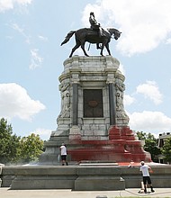 Workers with Envirowash scrub and power wash the base of the Lee statue on Monument Avenue last Saturday after the Confederate statue was vandalized sometime overnight between Aug. 3 and 4. The state Department of General Services, which owns and maintains the statue at Monument and Allen avenues, paid more than $4,400 for the cleanup.