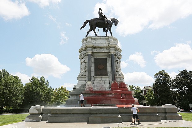 Workers with Envirowash scrub and power wash the base of the Lee statue on Monument Avenue last Saturday after the Confederate statue was vandalized sometime overnight between Aug. 3 and 4. The state Department of General Services, which owns and maintains the statue at Monument and Allen avenues, paid more than $4,400 for the cleanup.