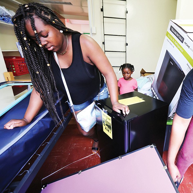 Left, Kavin Baines, 18, of Portsmouth gets a helping hand from her mother, Miki Baines, during last Saturday’s freshmen move-in at Virginia Union University. Orientation for members of the Class of 2022, along with classes for new students, started Monday on the Lombardy Street campus. Future student Kenzie Creekmur watches and takes notes about dormitory life in the background. 