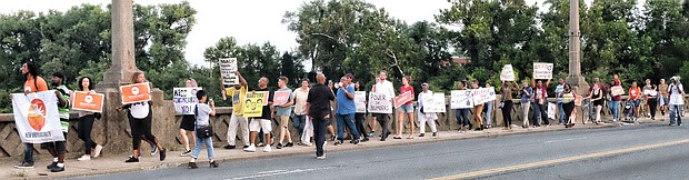 Members of the Southside Chapter of the New Virginia Majority call for Richmond Police transparency and accountability during a community march Monday night across the Mayo Bridge.