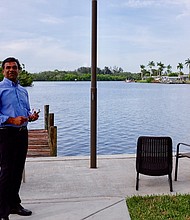 	Nezam Juman stands in the yard of his new house, which he's getting ready to remodel.