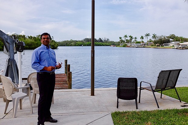 	Nezam Juman stands in the yard of his new house, which he's getting ready to remodel.