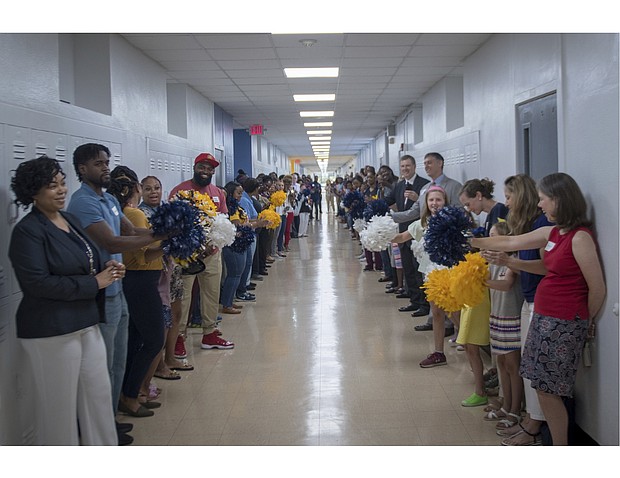 Teachers, parents, and community members cheer students on the first day of school for the 2018-2019 year