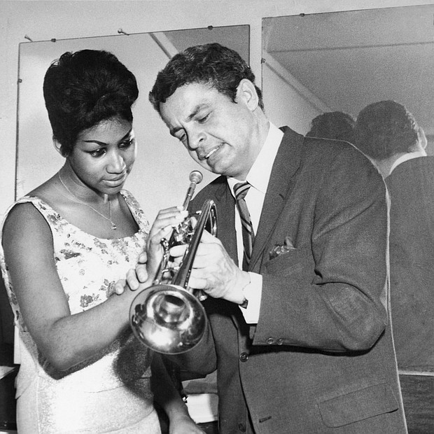 Aretha Franklin is taught how to properly play a trumpet by Canadian trumpeter Maynard Ferguson at Chicago's Sutherland Hotel in 1964.