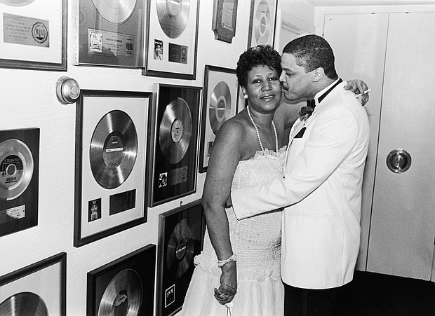 Aretha Franklin receives a kiss from beau Willie Wilkerson at Franklin's Birthday Celebration held at her sprawling suburban Detroit estate in 1987. 