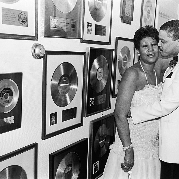 Aretha Franklin receives a kiss from beau Willie Wilkerson at Franklin's Birthday Celebration held at her sprawling suburban Detroit estate in 1987. 