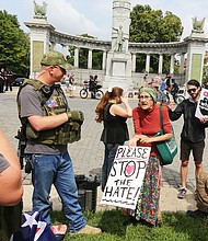 Mary Atkins, 73, takes her argument to stop the hate directly to the group of about 15 neo-Confederates, several carrying military-style weapons, who staged a rally Sunday to call for keeping the statue of Confederate President Jefferson Davis on Monument Avenue. Counterprotesters, who want the statues honoring Confederates to be removed, arrived early and took over the space directly at the foot of the monument.