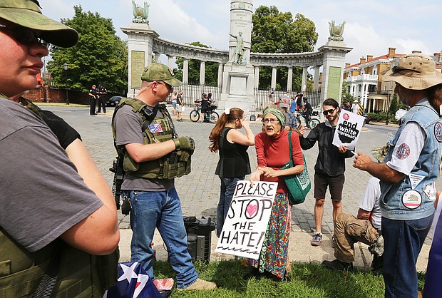 Mary Atkins, 73, takes her argument to stop the hate directly to the group of about 15 neo-Confederates, several carrying military-style weapons, who staged a rally Sunday to call for keeping the statue of Confederate President Jefferson Davis on Monument Avenue. Counterprotesters, who want the statues honoring Confederates to be removed, arrived early and took over the space directly at the foot of the monument.
