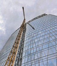 A towering crane’s reflection almost looks like a staircase rising up the side of this 20-story Downtown building under construction for Dominion Energy in the block bounded by 6th, 7th, Canal and Cary streets. Crews and cranes have been at the site since work began last year. The building will be known as 600 Canal Place when it opens next year. Dominion Energy has presented plans to a construct a second building to replace its 21-story Virginia headquarters, One James River Plaza, located next door at 701 E. Cary St. 