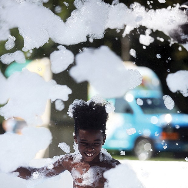 Last glorious days of summer
Deondre McKnight Williams, 9, frolics in the cool waters and bubbles of a “Foam Pit” set up last Friday at the Byrd Park Round House for Playground Day, hosted by the Richmond Department for Parks, Recreation and Community Facilities. Youngsters everywhere are fitting in the last days of fun before the new school year starts Sept. 4.(Regina H. Boone/Richmond Free Press)