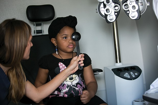Health checks
Malaysia Hubbard, 5, has her vision checked by an optometrist during last Friday’s free back-to-school physicals and health checks by the state’s Richmond Health District Office. The annual event, conducted in partnership with the Virginia Commonwealth University School of Nursing, provided the necessary checks for youngsters for Head Start and school entry.
